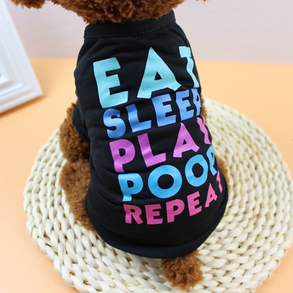 Brown dog wearing a black Eat Sleep Play Poop Repeat pet shirt viewed from behind