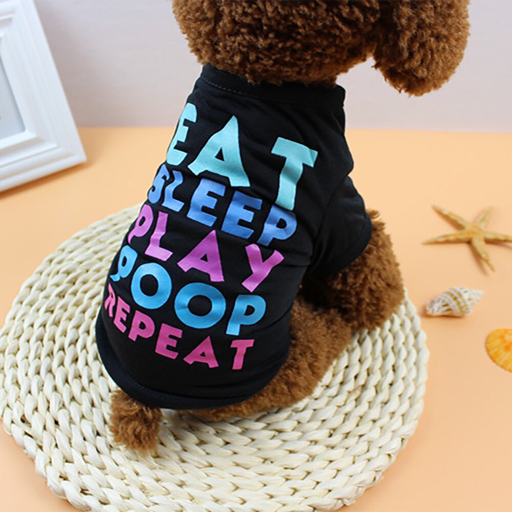 Brown dog wearing a black Eat Sleep Play Poop Repeat pet shirt viewed from the side and back