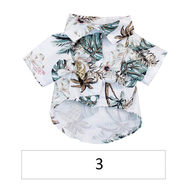 Front view of a white tropical pet shirt with pale flowers and green leaves labeled 3