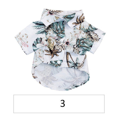 Front view of a white tropical pet shirt with pale flowers and green leaves labeled 3