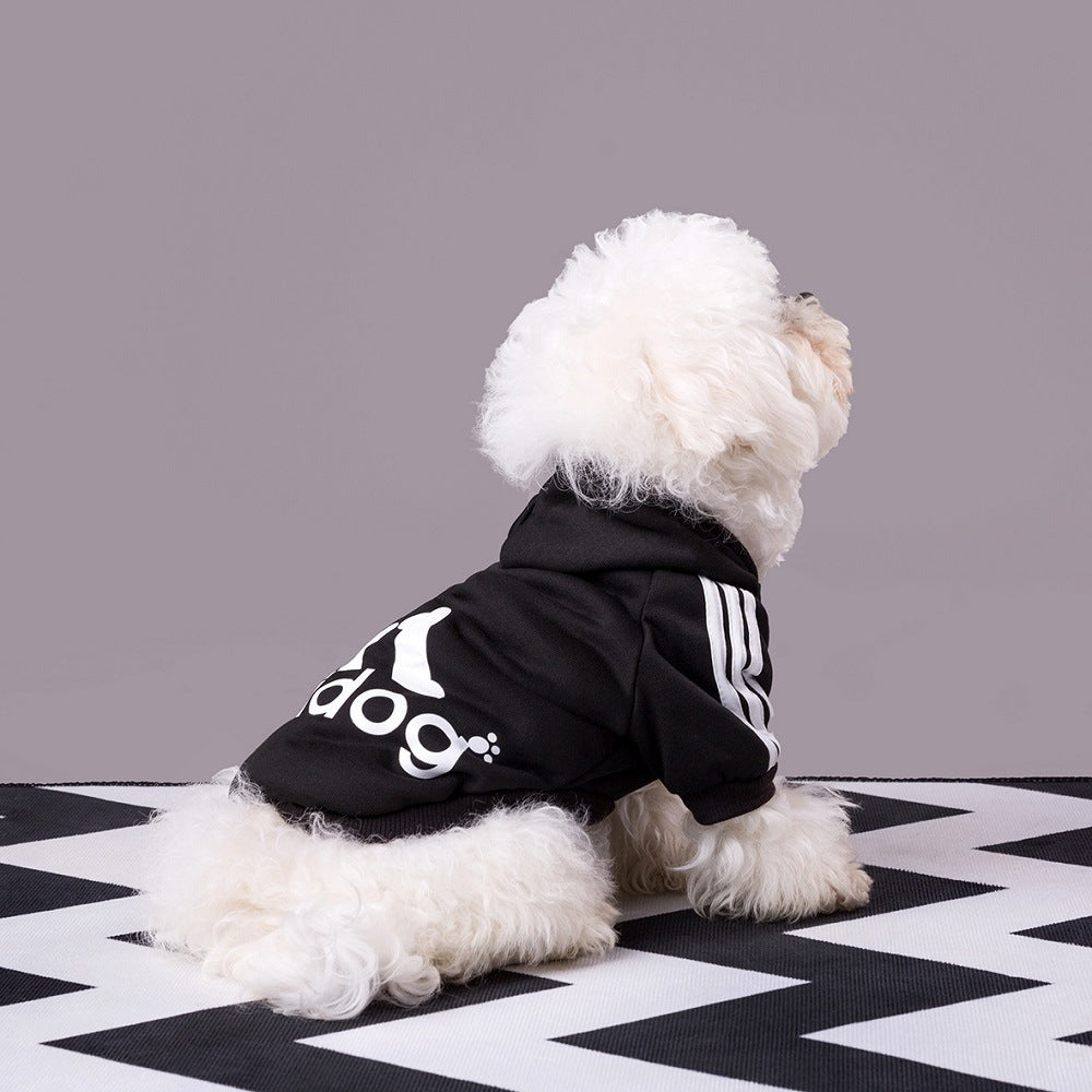 Dog wearing a black Adidog hoodie with white back graphics and shoulder stripes