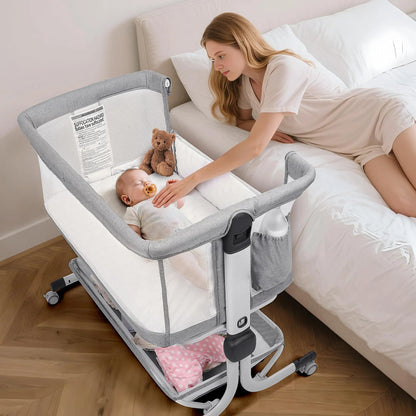 Woman leaning over a gray bedside bassinet with a baby and teddy bear inside.