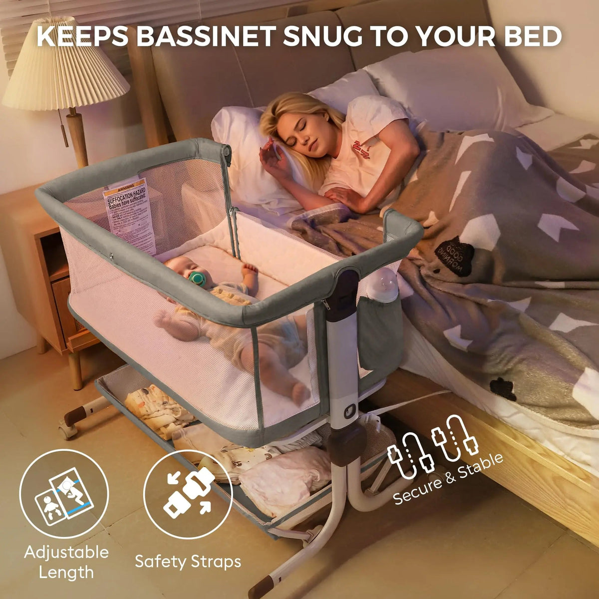 Gray bedside bassinet next to a bed, with adjustable-length and strap callouts.