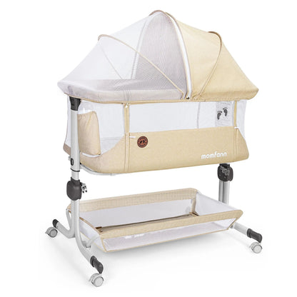 Beige Momfann bedside bassinet with mesh sides, canopy, lower storage basket, and wheeled frame.