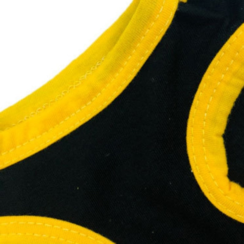 Closeup of yellow neckline and armhole trim on a black pet shirt